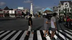 Warga melintas di sekitar perempatan Tugu Pal Putih Yogyakarta, Sabtu (26/12/2020). Proses penataan kawasan Tugu Pal Putih Yogyakarta telah rampung dilakukan, dan kini area yang menjadi salah satu ikon kota Yogya terlihat lebih rapi dan indah tanpa kabel melintang. (Liputan6.com/Helmi Fithriansyah)