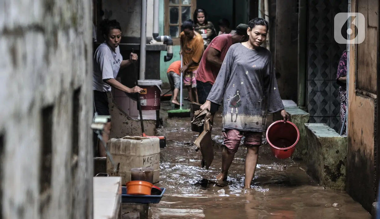 Warga membersihkan lumpur dan sampah saat banjir di permukiman Kebon Pala, Jatinegara, Jakarta, Minggu (25/10/2020). Hampir 12 jam banjir kiriman dari Bogor itu masih merendam permukiman warga di RT 11 RW 05 Kebon Pala dengan ketinggian mencapai pinggang orang dewasa.  (merdeka.com/Iqbal Nugroho)