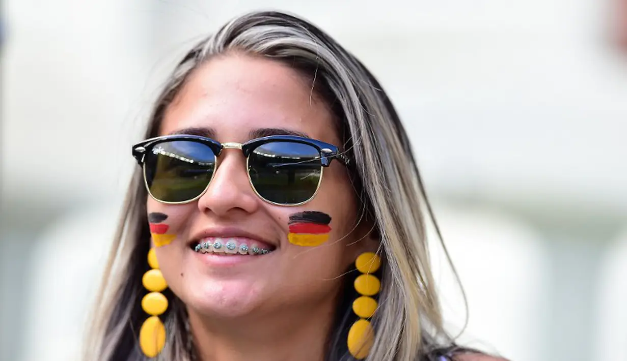Seorang suporter cantik tersenyum sebelum Jerman berlaga melawan Ghana di The Castelao Stadium, Fortaleza (21/06/2014) (AFP PHOTO/JAVIER SORIANO)