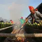 Bambu-bambu berisi beras ketan dengan campuran bahan lain dibakar oleh warga untuk pemecahan rekor pembakaran nasi bambu terbanyak. Tradisi Kuliner yang juga disebut nasi bambu itu dipamerkan dalam Festival Danau Poso tahun 2022. (Foto: Heri Susanto/ Liputan6.com).