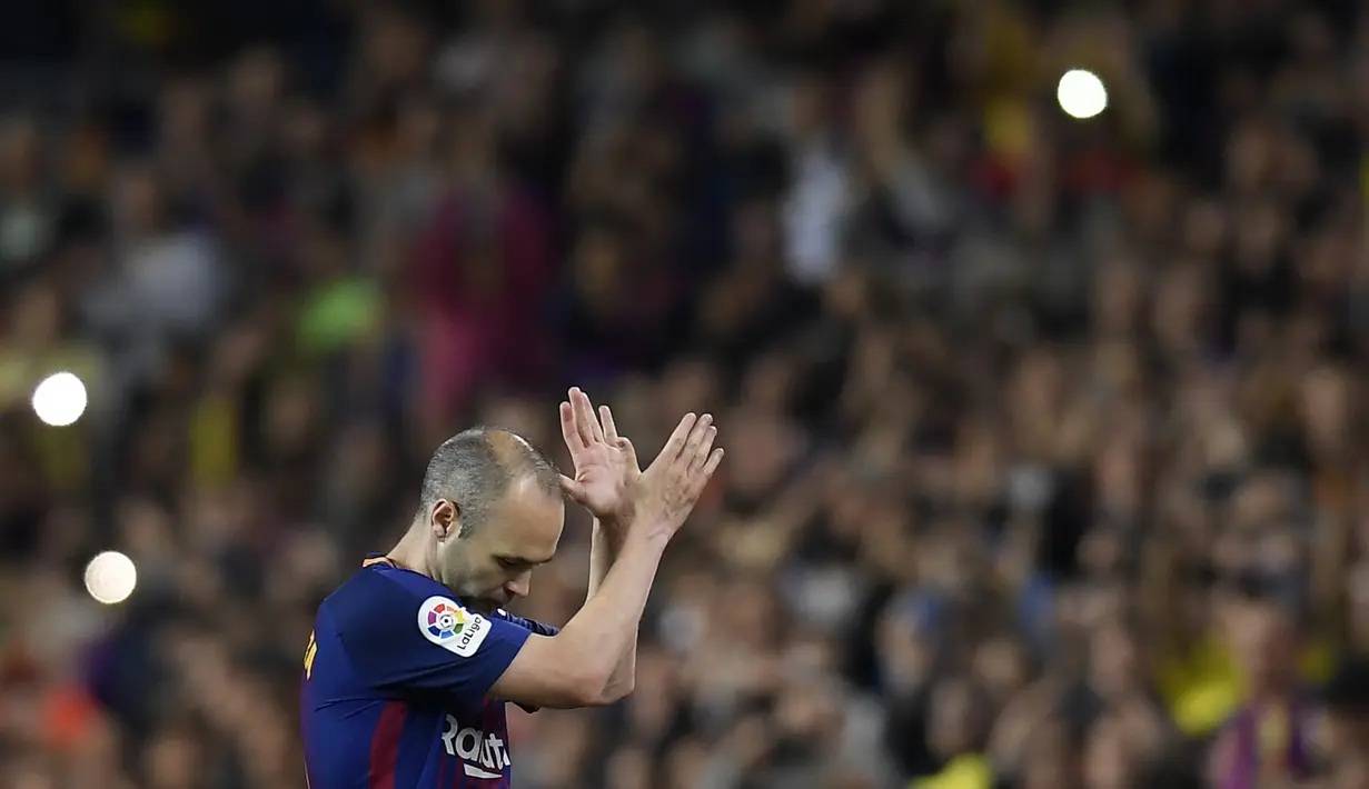 Gelandang Barcelona, Andres Iniesta, menyapa suporter usai melawan Real Madrid pada laga La Liga Spanyol di Stadion Camp Nou, Barcelona, Minggu (6/5/2018). Sepanjang karier dirinya mempersembahkan 32 trofi untuk La Blaugrana. (AFP/Lluis Gene)