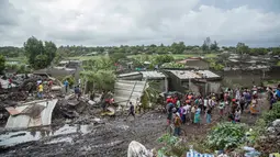 Sejumlah warga melihat proses pencarian para korban yang tertimbun gunungan sampah longsor di ibu kota Mozambik, Maputo,  Senin (19/2). Hujan lebat diperkirakan merupakan pemicu insiden di distrik miskin Maputo itu. (MAURO VOMBE / AFP)