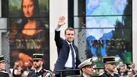 Presiden terpilih Prancis Emmanuel Macron melambaikan tangan saat berparade di jalan Champs Elysees setelah upacara peresmian sebagai Presiden Prancis, Paris, Minggu (14/5). (AFP PHOTO / CHARLY TRIBALLEAU)
