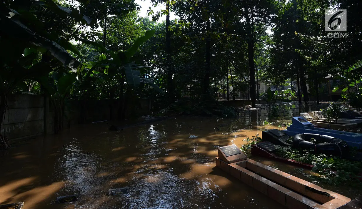Tempat pemakaman terendam banjir di kampung Arus Cawang, Jakarta Timur, Jumat (26/4). Ketinggan banjir kurang lebih satu meter terjadi akibat luapan kali Ciliwung dan intensitas curah hujan di kawasan Bogor Jawa Barat sangat tinggi sehingga aktivitas warga terhambat. (merdeka.com/Imam Buhori)