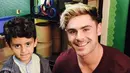 Dalam foto tersebut, Zac Efron sedang asyik menikmati suasana berkumpul bersama beberapa anak kecil. (twitter/Bintang.com)