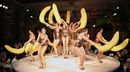 Pose para model dengan buah pisang  saat memperagakan busana karya Charlotte Olympia dalam Fashion Week Spring/Summer 2017 di London, Inggris, (18/9). (REUTERS/Neil Hall)