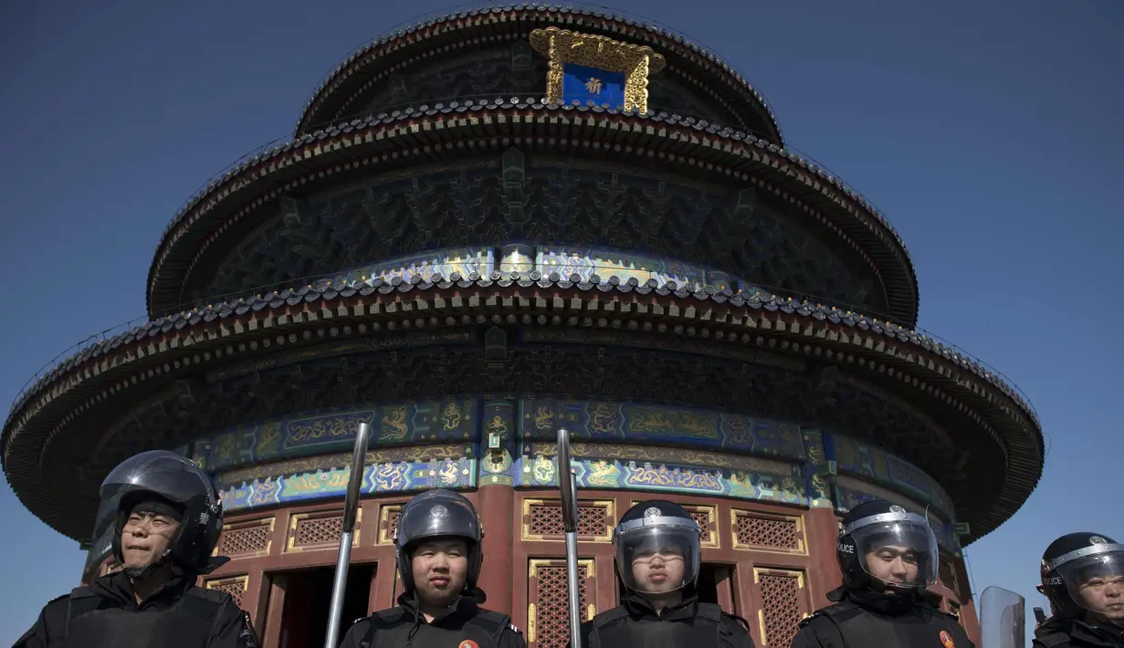 Petugas polisi mengamankan sebuah area selama liburan Tahun Baru Imlek di Kuil Surga di Beijing (20/2). Warga China tengah liburan selama seminggu yang menandai dimulainya Tahun Anjing. (AFP Photo/Nicolas Asfouri)