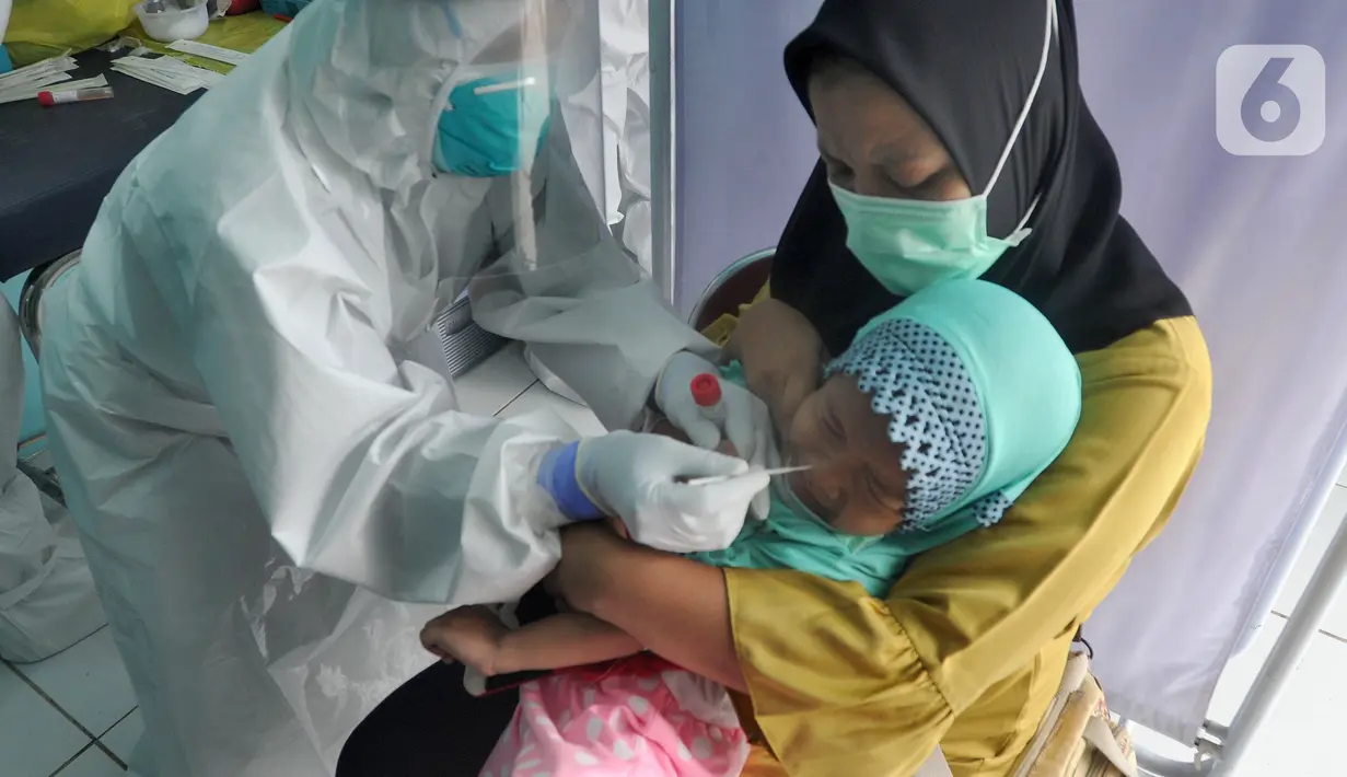 Paramedis melakukan swab test PCR kepada seorang anak di Puskesmas Kramat Jati, Jakarta Timur, Rabu (13/1/2020). Setiap harinya, Puskesmas Kramat Jati menyediakan kuota 300 swab test PCR  secara gratis untuk memutus mata rantai penyebaran COVID-19. (merdeka.com/Arie Basuki)