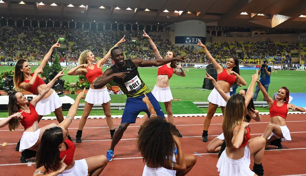 Pelari Usain Bolt melakukan selebrasi menari bersama wanita-wanita cantik di Stadium Louis II, Monaco, (21/7). Usain Bolt asal Jamaika menjuarai kejuaaran atletik lari 100m Diamond League. (AFP Photo/Yann Coatsaliou)