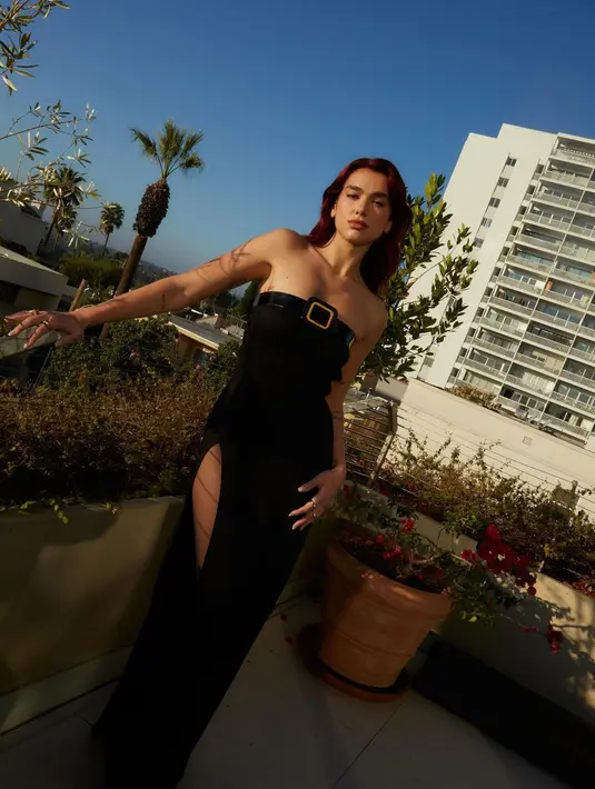 Lagi, Dua Lipa dibalut sebuah dress panjang berwarna hitam, tanpa tali. Detail seperti belt di bagian atas ujungnya dan high slit mempercantik penampilan Dua Lipa di sini. [Foto: Instagram/dualipa]