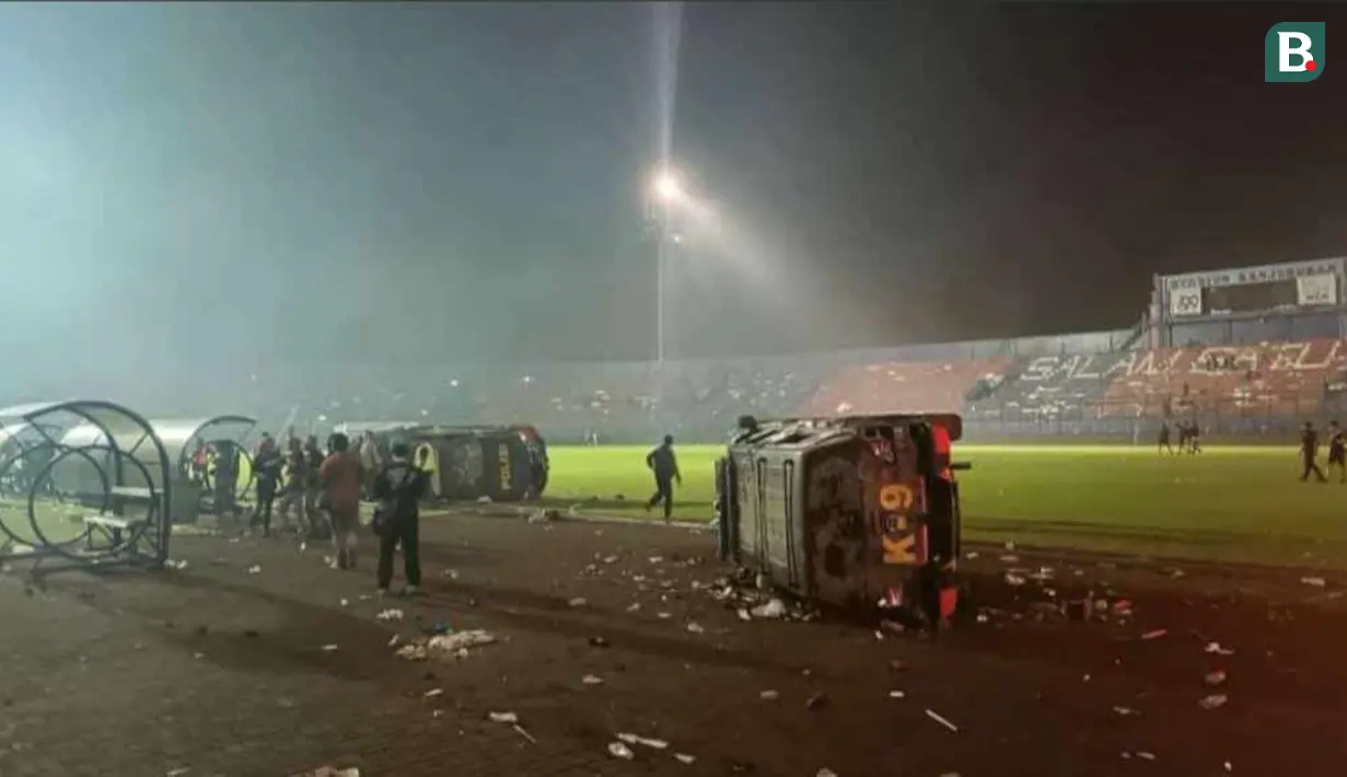 <p>Suasana Stadion Kanjuruhan, Malang, setelah pertandingan antara Arema FC dan Persebaya Surabaya pada pekan 11 Liga 1 2022/2023 berakhir, Sabtu (1/10/2022). Tampak mobil kepolisian rusak karena insiden yang terjadi. (Bola.com/Iwan Setiawan)</p>