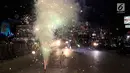 Warga menyalakan kembang api di tengah pawai untuk memeriahkan malam takbiran di sepanjang Jalan Mas Mansyur, Tanah Abang, Jakarta Pusat, Kamis (14/6) malam. (Liputan6.com/Johan Tallo)