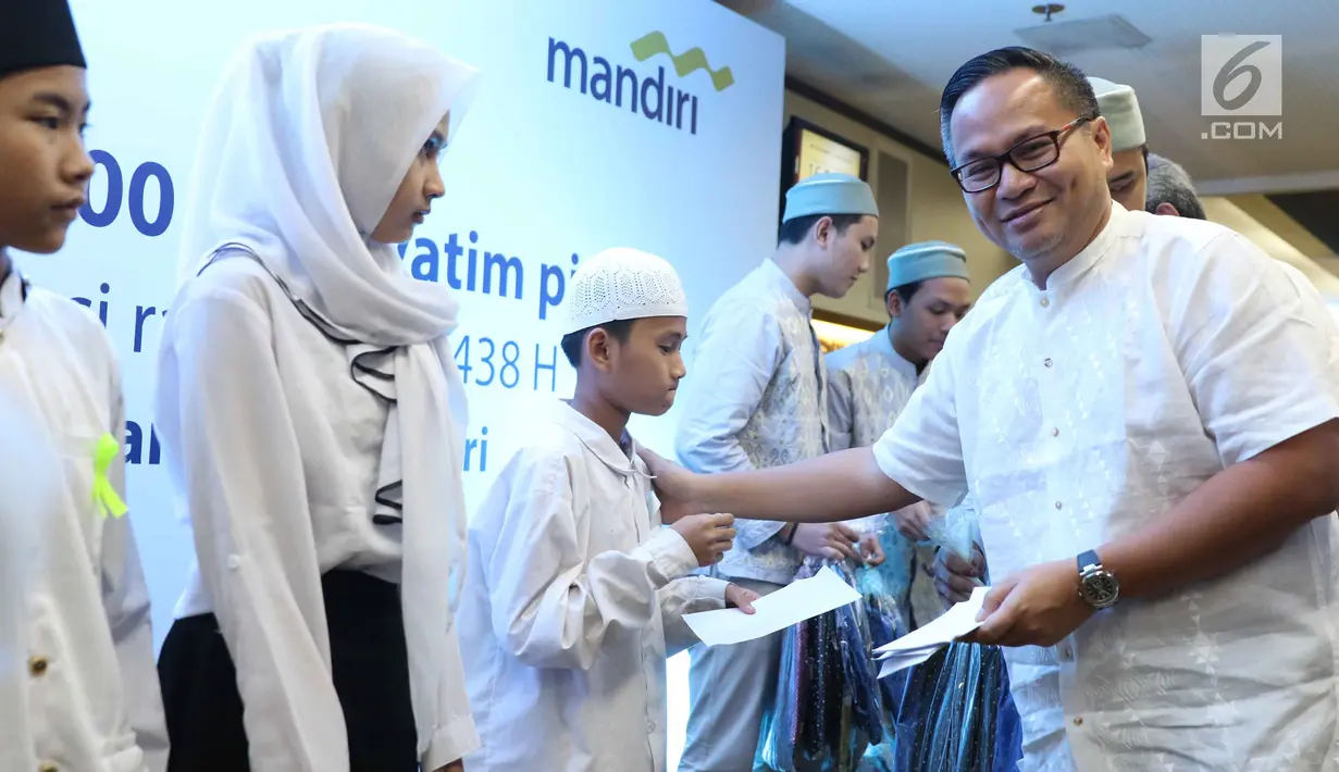 Direktur Utama Bank Mandiri Kartika Wirjoatmodjo tengah memberikan bingkisan Ramadan kepada sejumlah anak yatim di Jakarta, Minggu (11/6). Santunan ini sebagai bentuk empati dan wahana berbagi kebahagiaan di bulan Ramadan. (Liputan6.com/Angga Yuniar)