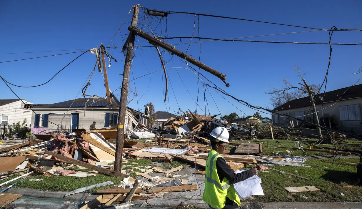 Seorang karyawan Entergy bekerja di lokasi setelah tornado merusak kabel listrik dan rumah di Tita Street di Algiers, sebuah lingkungan di New Orleans, Kamis (15/12/2022). Ribuan orang di Louisiana kehilangan aliran listrik usai terjangan badai. (David Grunfeld/The Times-Picayune/The New Orleans Advocate via AP)
