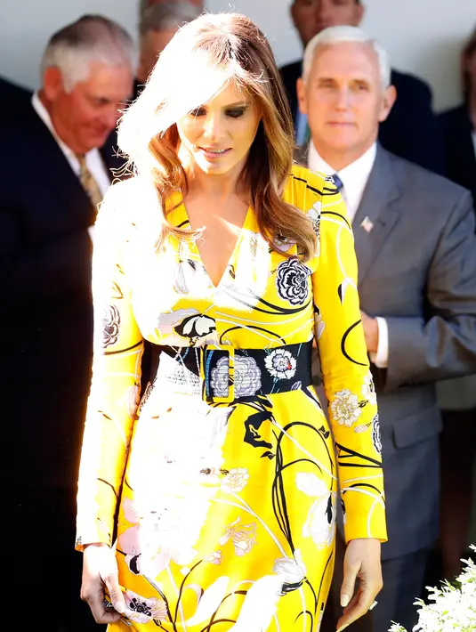 Ibu Negara AS, Melania Trump, saat menyambut kedatangan PM India, Narendra Modi di Gedung Putih, Senin (26/6). Melania Trump memberi siluet pada tubuhnya dengan belt hitam besar yang juga bermotif bunga dari label yang sama. (AP/Alex Brandon)