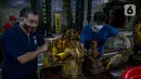 Para jemaat membersihkan patung yang ada di Vihara Amurva Bhumi, Jakarta, Kamis (4/2/2021). Ritual mencuci patung dewa serta bersih-bersih ini dilakukan dalam rangka menyambut perayaan Tahun Baru Imlek 2572. (Liputan6.com/Faizal Fanani)