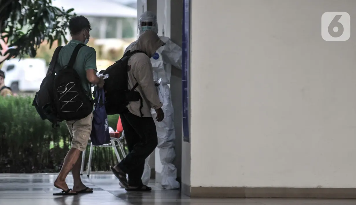 Tenaga kesehatan mendampingi pasien OTG COVID-19 yang tiba di Rusun Nagrak, Cilincing, Jakarta, Senin (21/6/2021). Koordinator Lapangan RSDC Wisma Atlet Kemayoran Letkol Arifin mengungkapkan 33 pasien OTG dari Jakarta Utara diisolasi di Rusun Nagrak. (merdeka.com/Iqbal S. Nugroho)