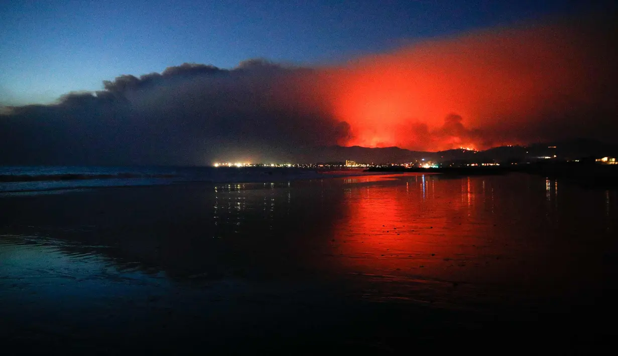 Kobaran api dan asap membumbung tinggi saat menghanguskan ribuan hektar lahan dan pemukiman di Ventura, California, AS (5/12). Api juga melalap permukiman warga, menyebabkan ribuan orang terpaksa mengungsi. (AP Photo / Noah Berger)