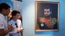 Para pengunjung mengamati lukisan megabintang Mesir, Mohamed Salah selama Piala Dunia 2018 di Museum of Academy of Arts, Saint Petersburg, Rusia, Rabu (20/6). Para bintang sepak bola dunia dilukis layaknya seorang jenderal militer. (AP/Dmitri Lovetsky)