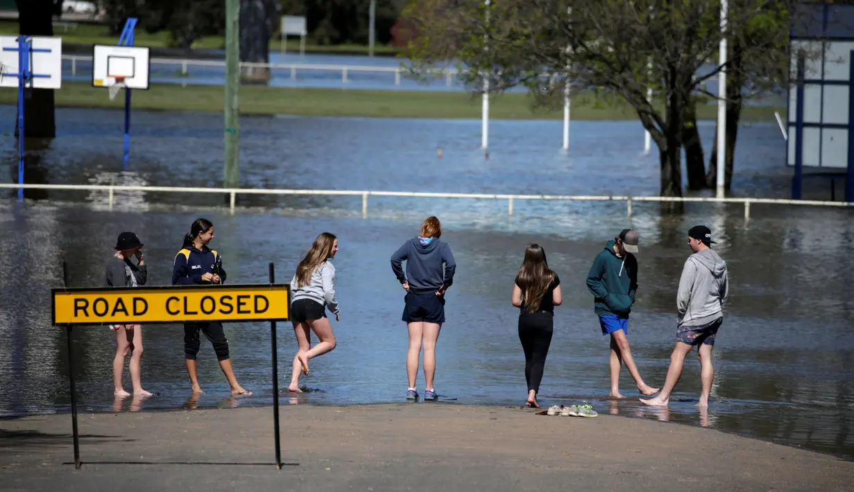 Warga melihat banjir yang melanda Kota Forbes, kawasan pedalaman di New South Wales, Australia, Selasa (27/9). Banjir ini merupakan banjir terparah sejak 26 tahun terakhir. (REUTERS / Jason Reed)