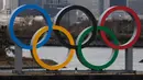 Pekerja berjalan di kapal tongkang yang membawa Cincin Olimpiade di Distrik Odaiba, Tokyo, Jepang, Jumat (17/1/2020). Cincin Olimpiade dengan tinggi 15,3 meter dan panjang 32,6 meter tersebut akan berada di sana hingga Olimpiade 2020 berakhir. (AP Photo/Jae C. Hong)