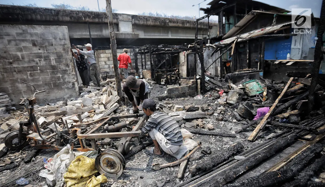 Sejumlah warga mengais sisa sisa barang paska kebakaran di permukiman kumuh di RW 02 Kampung Walang, Lodan Raya, Jakarta, Minggu (25/8). Sebanyak 420 jiwa saat ini mengungsi pasca-kebakaran, di sebuah tenda darurat. (Liputan6.com/Faizal Fanani)