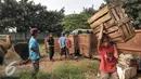 Sejumlah pedagang membantu petugas membersihkan lokasi yang nantinya akan dibangun sebagai pusat perkulakan, Jakarta, Jumat (2/9). Di targetkan pembangunan pusat perkulakan tersebut akan rampung pada Desember mendatang. (Liputan6.com/Yoppy Renato)