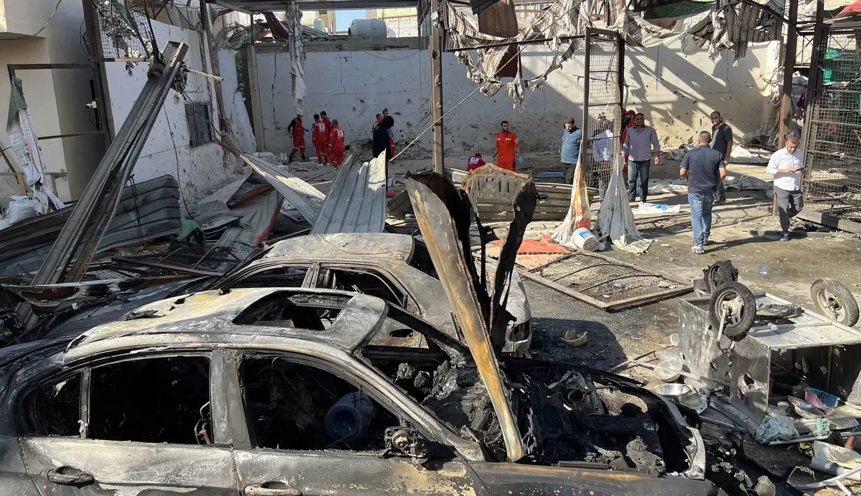 Serangan menargetkan area yang padat penduduk di dalam Ain al-Hilweh, kamp pengungsi Palestina terbesar di Lebanon, dekat kota Sidon. Tampak dalam foto, petugas medis memeriksa kondisi puing-puing mobil di kamp pengungsi Palestina Ain al-Hilweh, dekat Sidon di selatan Lebanon, pada Rabu 19 November 2025. (Mahmoud ZAYYAT/AFP)