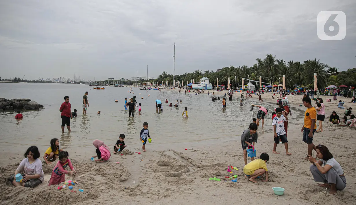 Pengujung berwisata di Pantai Ancol, Jakarta, Rabu (28/12/2022). Isu cuaca yang kurang bersahabat pada hari ini, tidak menyurutkan keinginan warga menghabiskan libur untuk berwisata di kawasan wisata Ancol. (Liputan6.com/Faizal Fanani)