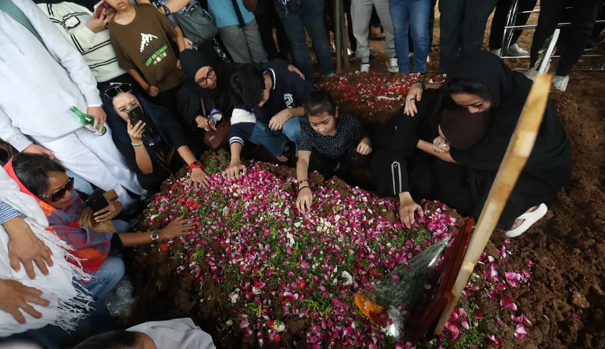 Istri Gary Iskak, Richa Novisha (kedua kanan), bersama anak-anaknya dan kerabat berada di dekat pusara sang suami di Taman Pemakaman Umum (TPU) Tanah Kusir, Jakarta Selatan, Sabtu (29/11/2025). (Kapanlagi.com/Budy Santoso)