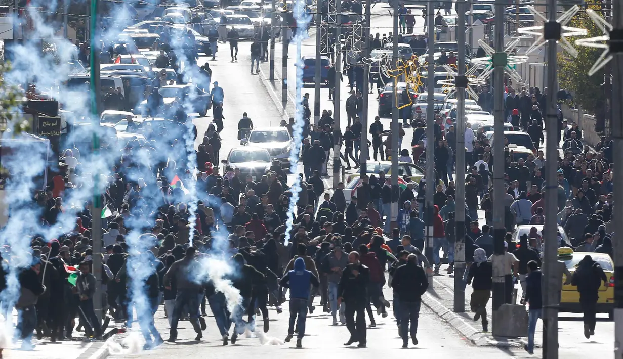 Warga Palestina saat bentrok dengan petugas Israel di kota Bethlehem, Tepi Barat, (7/12). Donald Trump juga menyerukan agar kedubes AS di Tel Aviv segera dipindah ke Yerusalem. (AP Photo/Nasser Shiyoukhi)