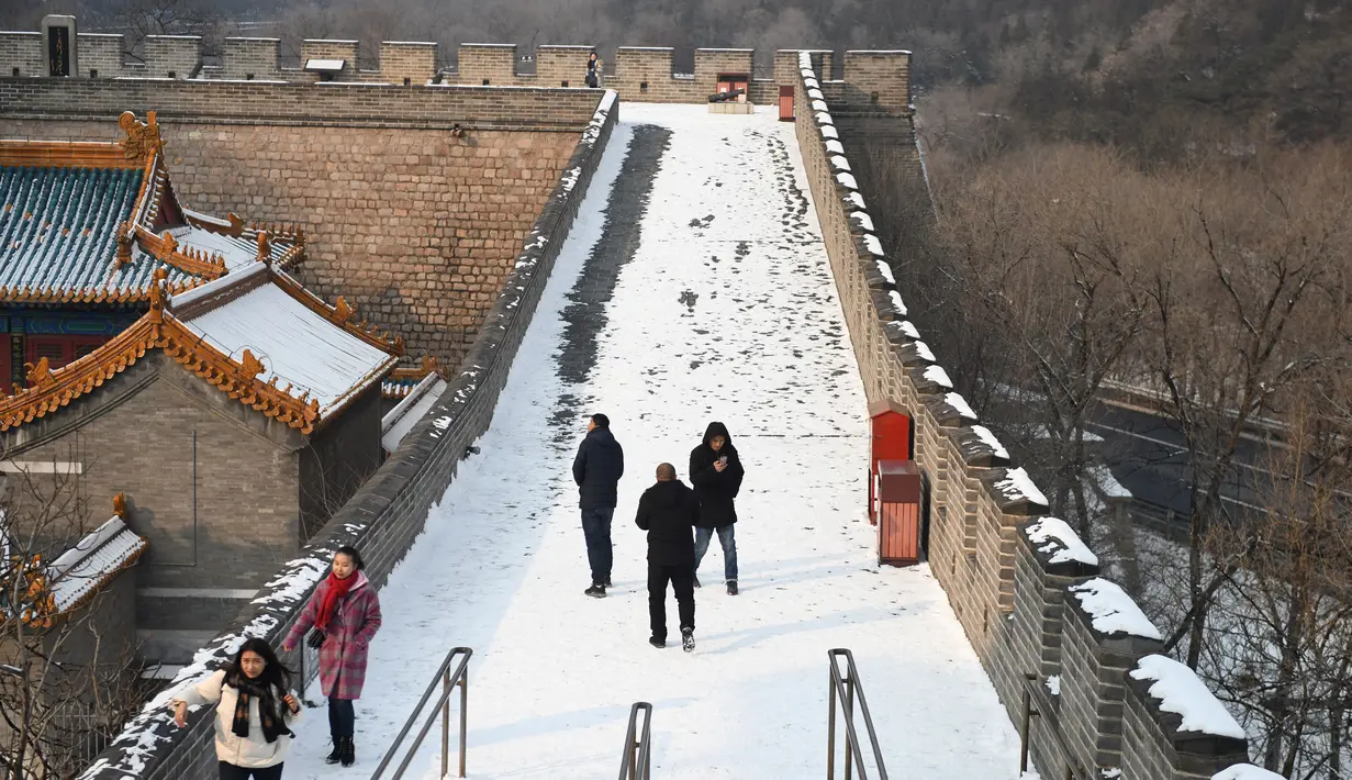 Sejumlah wisatawan saat menikmati liburan musim dingin di Tembok Besar China yang diselimuti salju di utara Beijing (6/1/2020). (AFP/Greg Baker)