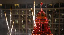 Orang-orang menonton lampu Natal dinyalakan di distrik perbelanjaan Country Club Plaza, Kansas City, Missouri, Amerika Serikat, 25 November 2021. Upacara malam Thanksgiving ini menampilkan lebih dari 200.000 lampu yang mencakup area 15 blok. (AP Photo/Charlie Riedel)