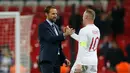 Usai pertandingan, Wayne Rooney bersalaman dengan sang pelatih Gareth Southgate pada laga persabahatan kontra Amerika Serikat yang berlangsung di Stadion Wembley, Inggris. Timnas Inggris menang 3-0. (AFP/Ian Kington)