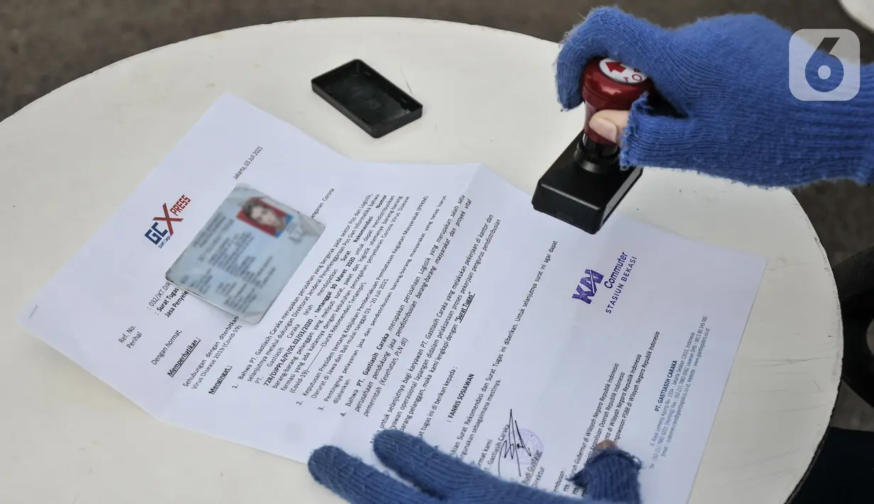 Petugas memberikan stempel sebagai bukti verifikasi STRP di Stasiun Bekasi, Jawa Barat, Selasa (13/7/2021). Pemeriksaan STRP guna menekan mobilitas masyarakat dan memutus penyebaran virus Covid-19 di transportasi umum. (merdeka.com/Iqbal S. Nugroho)