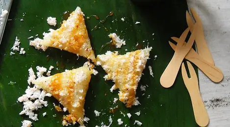 Kue lupis gula merah yang kenyal dan lezat, disajikan dengan taburan kelapa parut dan siraman saus gula merah