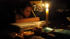 Seorang anak belajar dengan menggunakan lilin akibat pemadaman listrik di San Cristobal, Venezuela, Senin (25/4). Venezuela menerapkan pemadaman listrik selama empat jam sehari untuk menghadapi krisis energi yang memburuk. (REUTERS/Carlos Eduardo Ramirez)