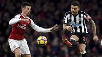 Pemain Arsenal, Laurent Koscielny (kiri)  berusaha menghalau bola sepakan pemain Newcastle United, Joselu pada lanjutan Premier League di Emirates Stadium, London, (16/12/2017). Arsenal menang 1-0.  (Joe Giddens/PA via AP)