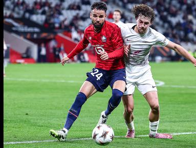 Pemain LOSC Lille, Calvin Verdonk (kiri) berebut bola dengan pemain SK Brann, Denzel De Roeve dalam laga Liga Europa 2025/2026 di Stade Pierre-Mauroy in Villeneuve-d'Ascq, Prancis, Kamis (25/09/2025) waktu setempat. (AFP/Sameer Al-Doumy)