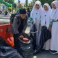 Para santri tengah memunguti sampah yang berserakan di halangan Otista, ALun-alun Garut, selepas perayaan Hari Santri Nasional (HSN) 2022 di Garut. (Liputan6.com/Jayadi Supriadin)