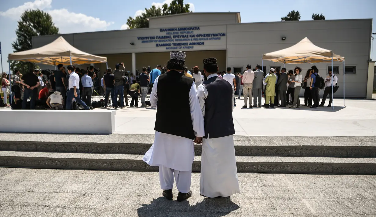 Umat muslim berdiri di luar bangunan masjid resmi pertama di Kota Athena, Yunani pada Jumat (7/6/2019). Bangunan seluas 1.000 meter persegi ini menghabiskan biaya 800.000 euro atau sekitar Rp12,5 miliar. (Aris MESSINIS / AFP)