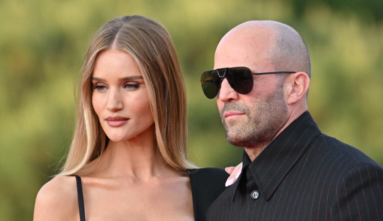 Aktor Inggris Jason Statham bersama pasangannyua Rosie Huntington-Whiteley tiba untuk pemutaran perdana film "Fast X", film kesepuluh dalam Fast & Furious Saga, di monumen Colosseum di Roma pada 12 Mei 2023. (AFP/Alberto Pizzoli)