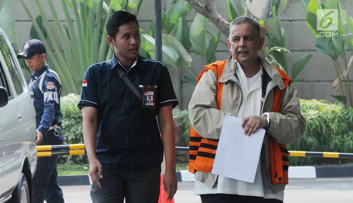 Direktur Utama nonaktif PLN Sofyan Basir (kanan) tiba di Gedung KPK, Jakarta, Kamis (27/6/2019). Sofyan berjalan menuju lobi KPK dengan memakai rompi tahanan dan tangan terborgol, tetapi dia terlihat menutupinya dengan lembaran kertas. (merdeka.com/Dwi Narwoko)