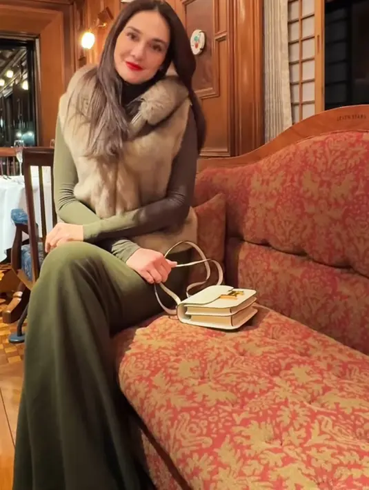 Luna Maya liburan ke Jepang bersama kekasihnya. Saat merasakan kereta di sana, Luna mengenakan vest berbulu coklat dipadukan inner dan celana hijau. Serta membawa tas Hermes putih. [@lunamaya]