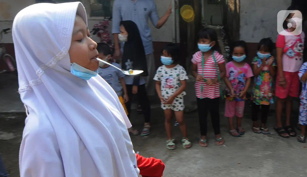 Seorang anak mengikuti lomba balap kelereng peringatan HUT Kemerdekaan ke-76 RI di Benda Baru, Pamulang, Tangsel, Selasa (17/8/2021). Di sejumlah kawasan pinggiran Jabotabek warga tetap melaksanakan peringatan HUT kemerdekaaan RI walau masih dalam status PPKM Level 4. (merdeka.com/Arie Basuki)