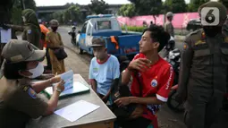 Petugas Satpol PP mendata pelanggar saat melakukan razia masker di depan Stasiun Klender, Jakarta, Selasa (10/5/2022). Pemerintah memastikan akan terus memperpanjang masa pemberlakuan pembatasan kegiatan masyarakat (PPKM) se-Indonesia hingga waktu yang belum ditentukan. (Liputan6.com/Faizal Fanani)