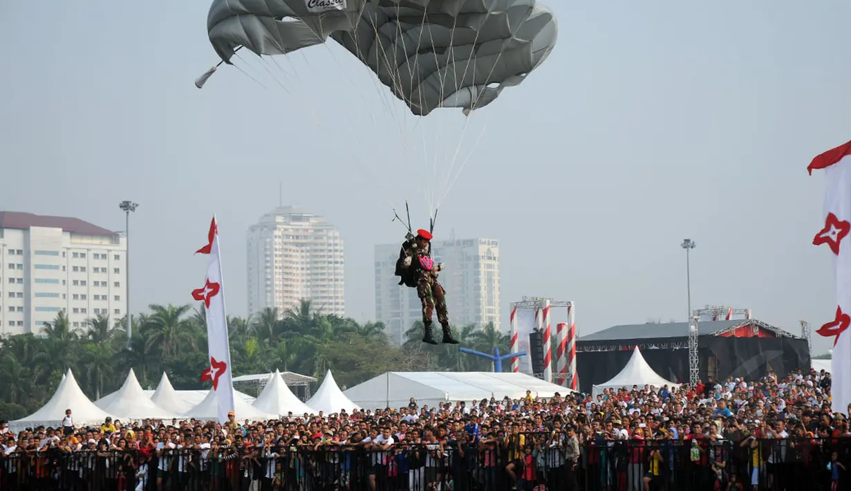 Salah satu peterjun wanita dari Komando Pasukan Khusus TNI AD bersiap mendarat di kawasan Tugu Monas, (31/8/2014). (Liputan6.com/Helmi Fithriansyah)