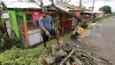 Seorang pria menyingkirkan pohon tumbang akibat badai dahsyat yang menghalangi tokonya di Ibu kota Fiji, Suva, Senin (22/2). Badai tropis Winston memporak-prandakan negara kepulauan Fiji hingga menewaskan sedikinya 10 orang. (REUTERS/Steven Saphore)