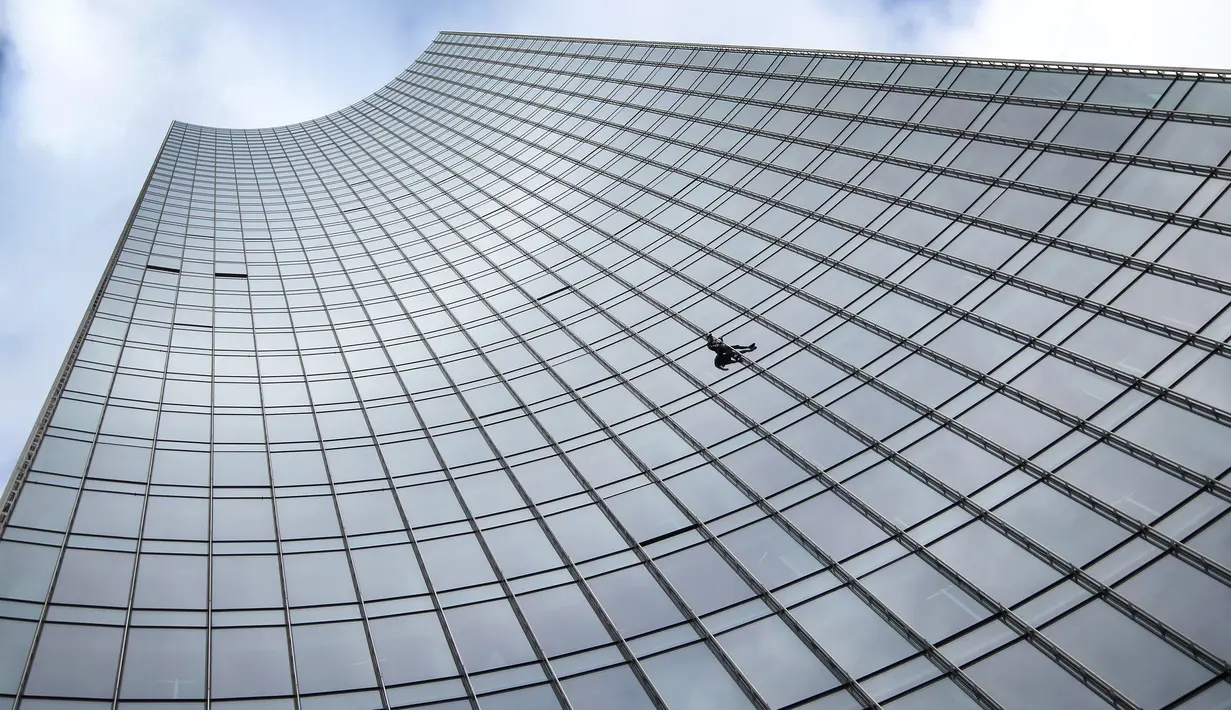 Pendaki kota Prancis, Alain Robert saat berusaha memanjat gedung XYZ di Frankfurt am Main, Sabtu (28/9/2019). Alain yang dikenal sebagai "The French Spiderman" kembali memanjat gedung tinggi di kota Jerman tersebut. (AFP Photo/Daniel Roland)
