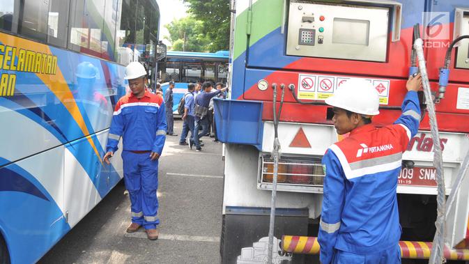 Petugas mempersiapkan selang gas untuk Bus BRT Trans Semarang di Pelataran Parkir Patra Jasa Semarang, Rabu (9/1). Sejumlah bus mulai beralih menggunakan Bahan Bakar Gas (BBG)  pada bus sedang (medium) . (Liputan6.com/Gholib)